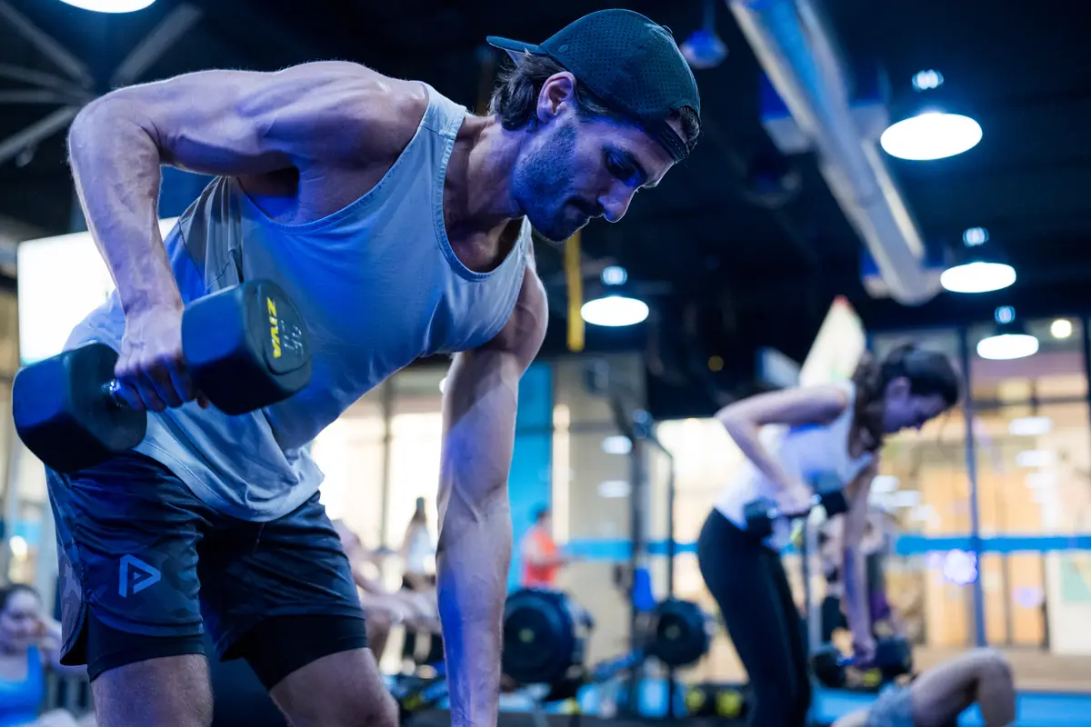 Man performing a single-arm dumbbell row during a SWEAT440 strength workout