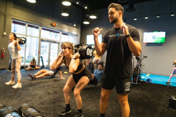 SWEAT440 Doral member coach and member working out gym class