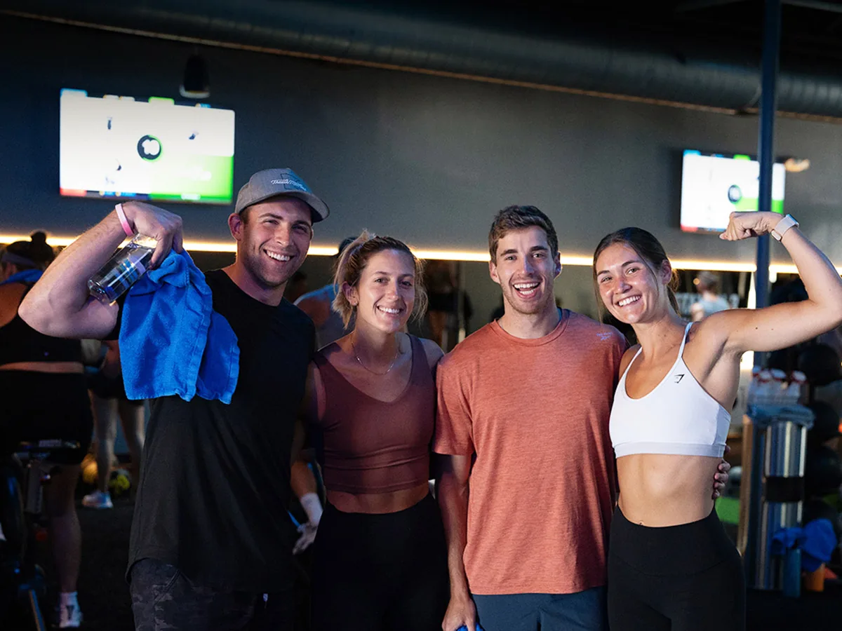 Diverse group of SWEAT440 members smiling together after a workout