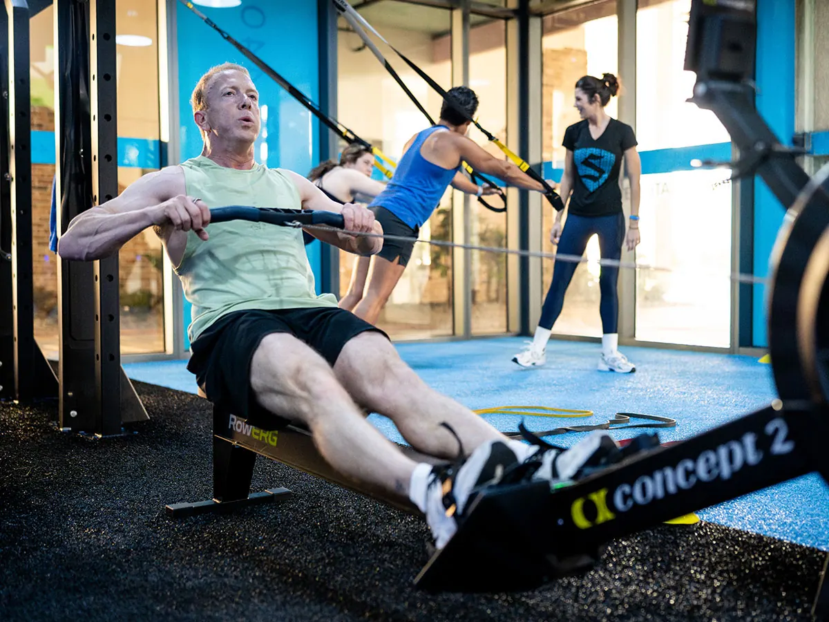 SWEAT440 coach guiding members through a conditioning station